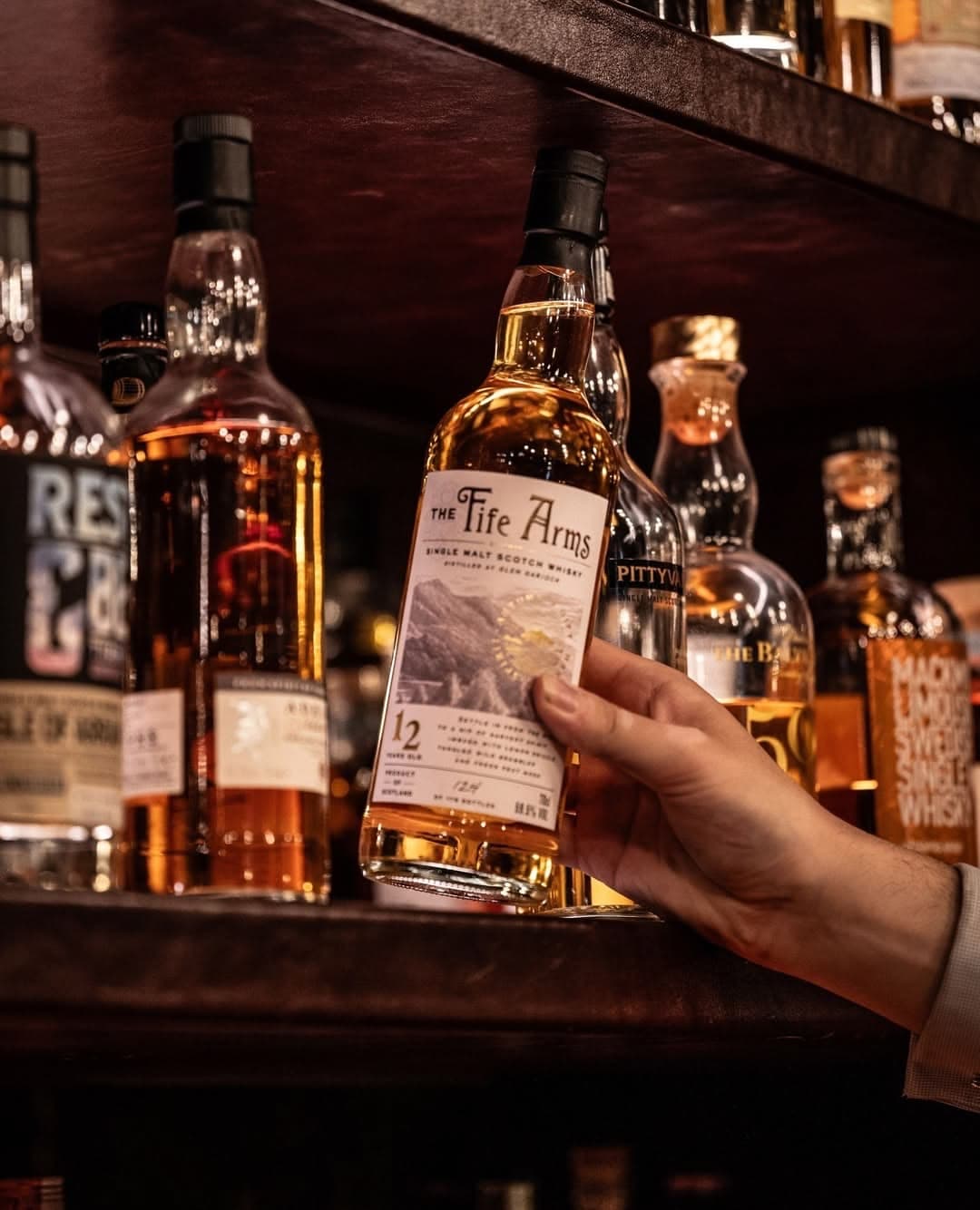 Whisky bottles behind a warmly lit bar